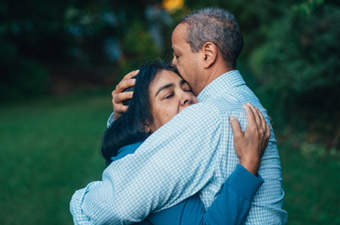 middle-aged couple hugs comfortingly